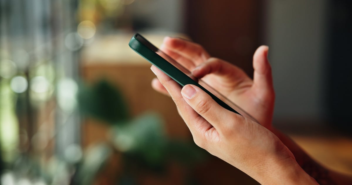 Hands scrolling social media and investment content on mobile phone
